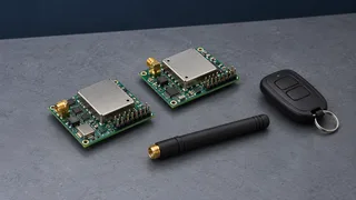 Illustration: Two generic RF receiver modules, a remote and a disconnected antenna on a gray workbench